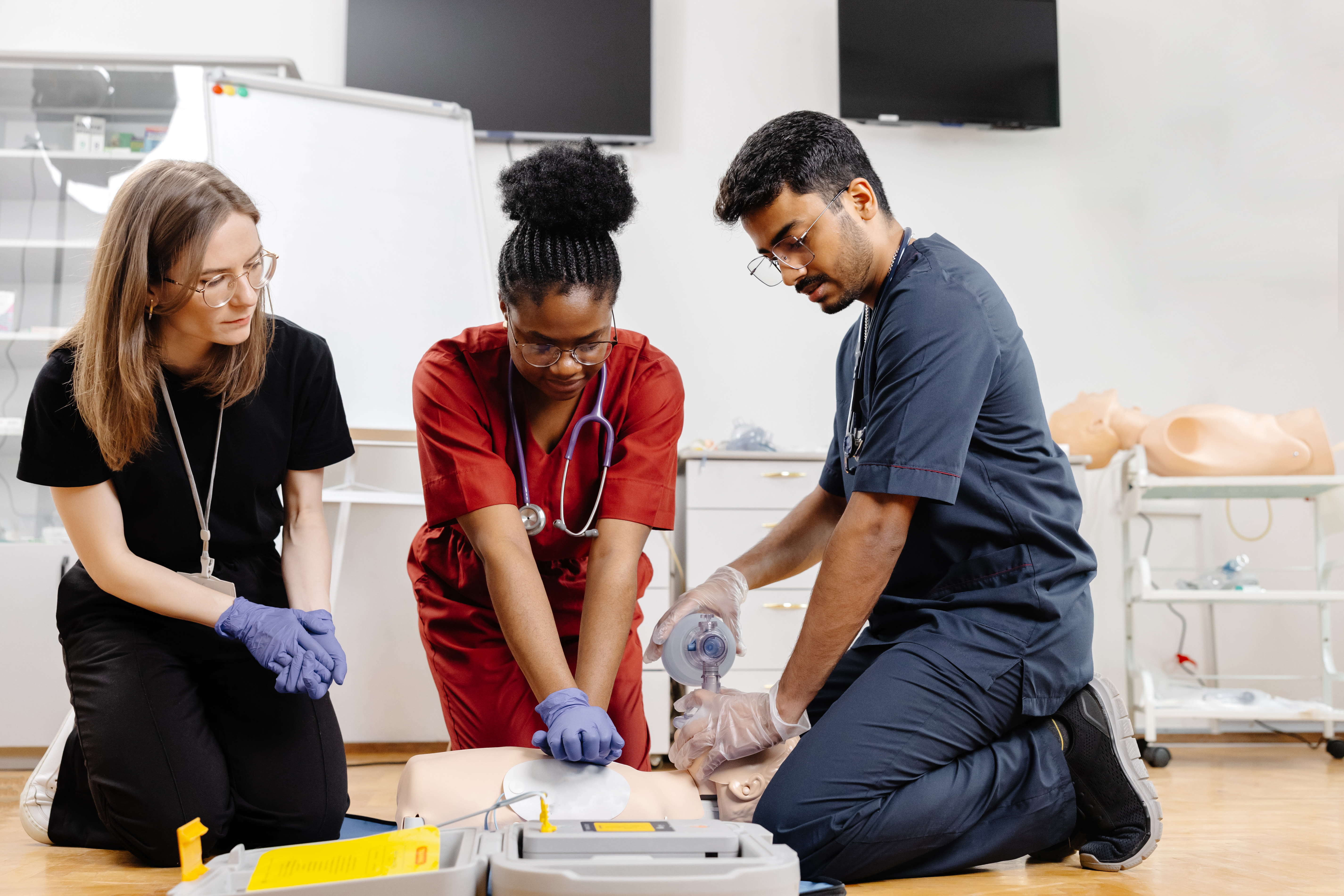Two medical aide students in a BLS class demonstrates their BLS skills with hospital dummy