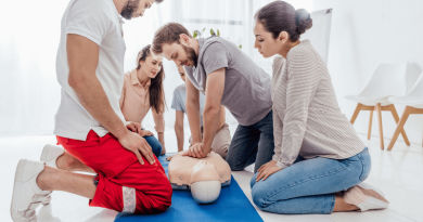 group of men and women practicing CPR compressions using a mannequin 