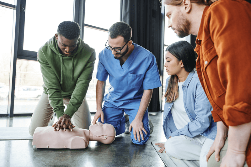 Four medical personnel practice CPR on a mannequin for ACLS training