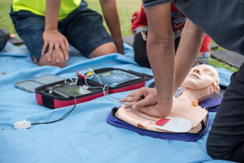A group of medical staff is training with a medical emergency dummy for an ACLS training